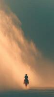 Cowboy riding through misty landscape during sunset in warm golden light photo