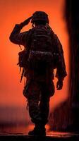 Soldier saluting against a dramatic sunset backdrop during a rainy moment in the field photo