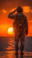 Soldier saluting at sunset by the ocean in a quiet moment of reflection and honor photo