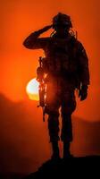 Soldier saluting against a vibrant sunset in a mountainous region photo