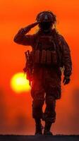 Soldier saluting during sunset while on duty in an outdoor training environment photo