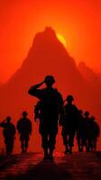 Silhouetted soldiers salute against a vibrant sunset backdrop in mountainous terrain, showcasing camaraderie and respect photo