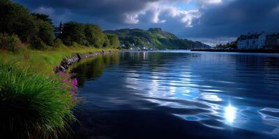 Serene waters reflect moody clouds near a quiet village at dusk in a coastal landscape photo