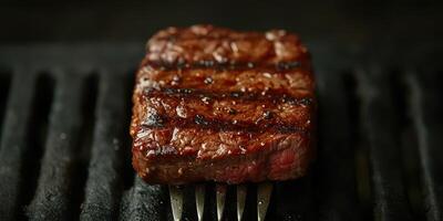 Juicy grilled steak resting on a fork with grill marks and a rich brown color photo