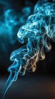 Colorful smoke swirls against a dark background, creating an ethereal visual effect photo