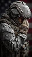 Soldier in tactical gear saluting with respect against a backdrop of the American flag photo