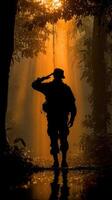 Soldier saluting in silhouette during sunrise amidst tropical forest setting photo