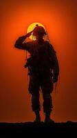 Soldier saluting against vibrant sunset backdrop in a desert landscape during evening hours photo