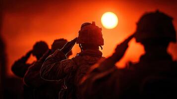 Soldiers saluting at sunset during a military ceremony in a desert location photo