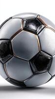 Silver and black soccer ball with detailed texture resting on a plain background at an indoor sports venue photo