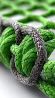 Detailed view of intertwined green and gray ropes forming a strong knot on a textured pattern background photo