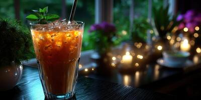 Refreshing iced beverage with mint served in a glass at twilight setting adorned with plants and soft lights photo