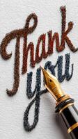 Creative thank you note with intricate hand lettering and a fountain pen on textured paper photo