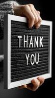 Hand holding a thank you sign with a black background highlighting gratitude and appreciation photo