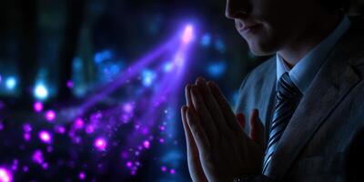 Person in suit with hands clasped, surrounded by glowing purple and blue lights at a mysterious location during an evening event photo