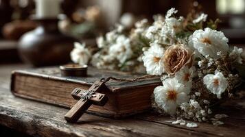 Antique book with wooden cross and bouquet of dried flowers on rustic table photo