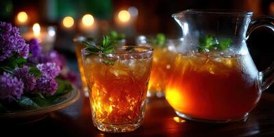 Refreshing iced tea served in glasses with a pitcher, surrounded by candles and flowers in a cozy evening setting photo