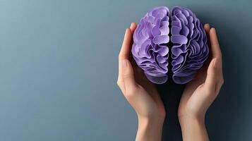 A person holding a purple paper brain photo