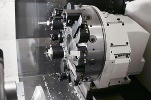 CNC turn mill machine chamfer cutting the metal shaft parts. The hi-technology metal working processing by Computer Numerical Control machine. photo