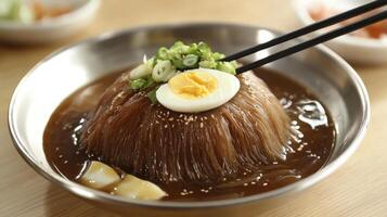 A bowl of ramen with an egg and chopsticks photo