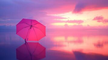 A pink umbrella is standing on the water at sunset photo