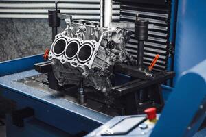 Three-cylinder engine repair on CNC machine, boring under the piston using machine with Computer Numerical Control. photo