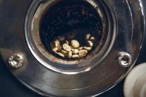 Close-up view of viewport of coffee bean roaster, in which viewport through window reveals section of roasting drum, filled with coffee beans. photo
