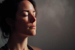 Calm woman with closed eyes, dark hair, and soft natural light on her face, creating a peaceful and serene atmosphere her expression is composed, reflecting meditation or relaxation photo