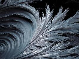Intricate frost patterns form a swirling, icy design resembling delicate, silvery feathers. The close-up texture emphasizes the organic, crystalline beauty of winter's artistic touch photo