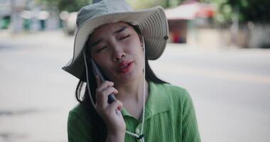 Handheld selective focus shot, Cheerful woman happily talks on the phone while standing on a sidewalk in the city. video