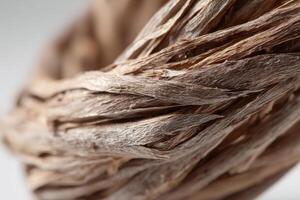 Tightly coiled natural fibers with a textured surface form an abstract structure in soft focus. The intertwined strands create an intricate pattern showcasing organic aesthetics photo