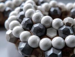 Intricate arrangement of geometric shapes including glossy white spheres, hexagonal prisms, and multifaceted dark gray polyhedrons creating an abstract and modern aesthetic photo
