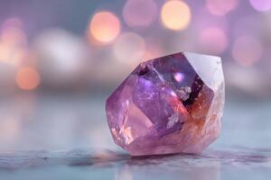 Sparkling purple crystal with faceted edges lying on smooth surface, surrounded by blurred bokeh lights in warm tones, highlighting its vibrant hues and intricate details photo