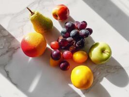 Assorted ripe fruits including grape bunches, a green apple, vibrant citrus, and a pear, are artfully arranged on a light surface, casting distinct shadows and showcasing texture photo