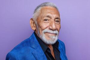 Smiling elderly man with white hair and beard in a vibrant blue jacket over a black shirt, gazing confidently photo