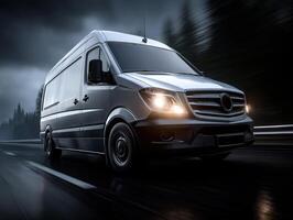 Silver van driving on a wet road under a cloudy sky at dusk, headlights on, blurred motion effect, trees visible in background, front view dominates the frame, no text visible photo