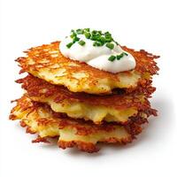 A stack of potato pancakes with sour cream and chives photo