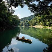 A man in a boat on a river surrounded by trees photo