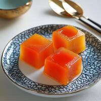 A plate with three pieces of orange jello on it photo