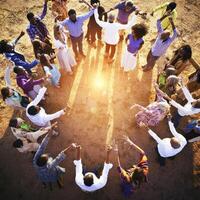 Group of people standing in circle with hands up photo