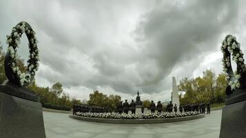 A 360 - view of a memorial with flowers and a statue photo