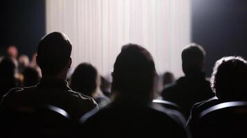 Silhouettes of people in a dark auditorium photo