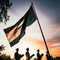 Military men standing in front of a flag at sunset photo