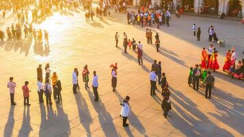 People walking in a square at sunset photo