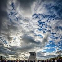 A crowd of people standing in front of a monument photo