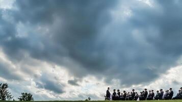 A group of people standing in a field under a cloudy sky photo