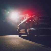 Retro car on the road at night with the sun shining photo