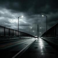 A car drives down a dark road under a stormy sky photo