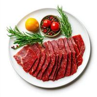 Sliced beef on a white plate with rosemary and lemon photo