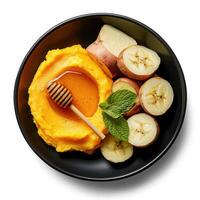 A bowl of mashed potatoes, bananas and honey photo